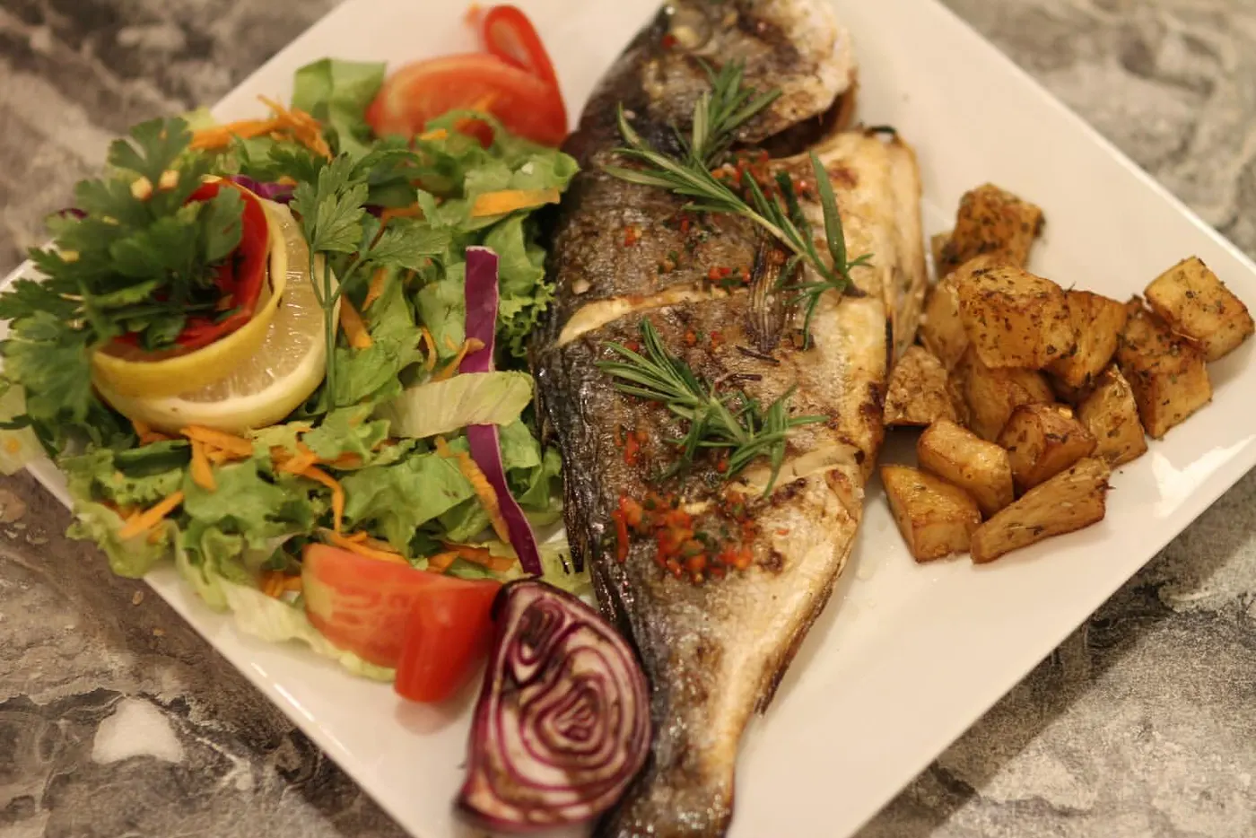Izgara levrek, taze salata ve fırın patates