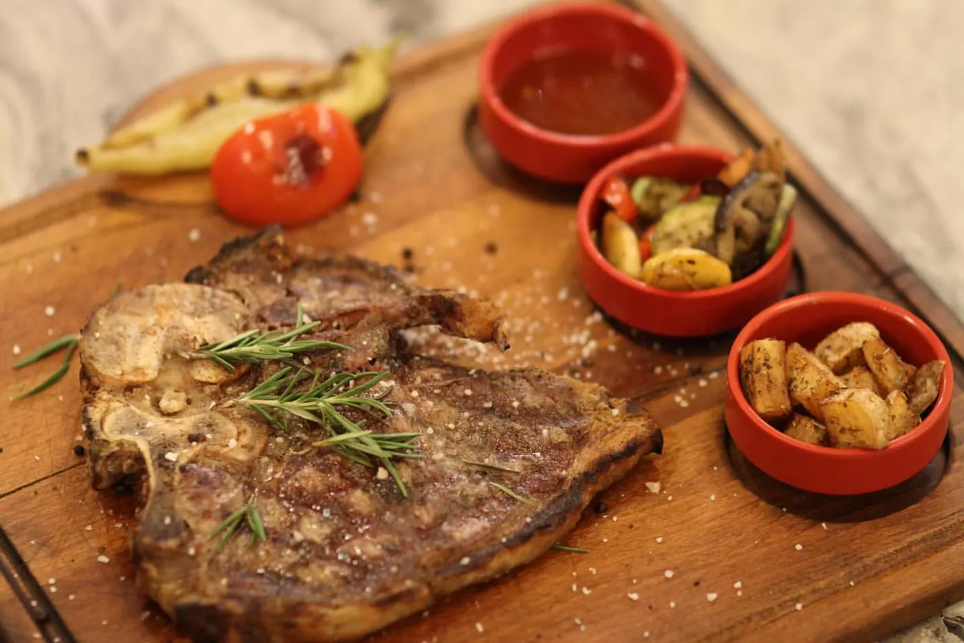T-Bone steak, ızgara sebzeler ve soslarla